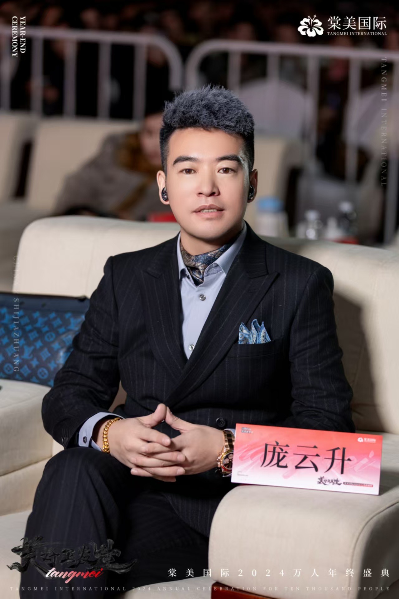庞云升身着深色西装出席棠美国际万人年终盛典
